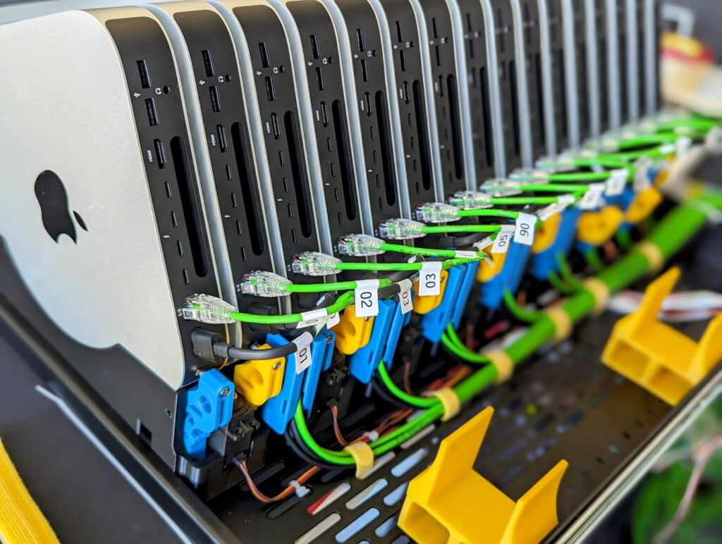Cluster de Mac mini montado em rack, com cabos de rede coloridos ligando cada nó